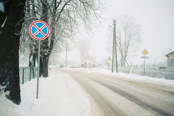 Snowy road with no-stopping sign in a winter town