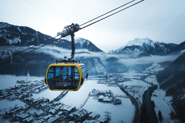 Yellow gondola over a snowy mountain village