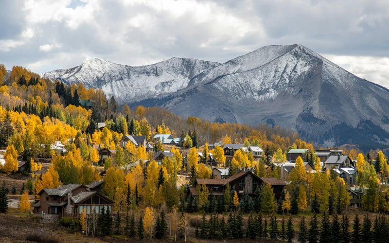 Colorado mountain town with gold aspens and snow-capped peak