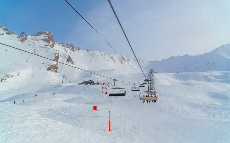 Ski lift gondola over snowy mountain slopes