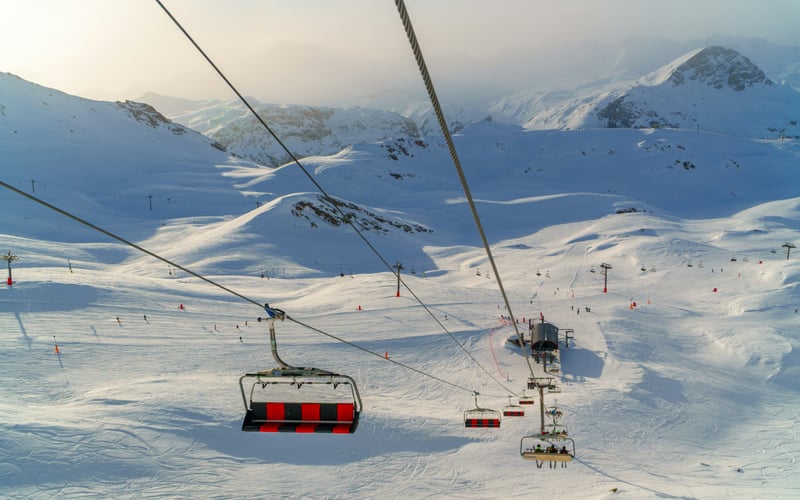 Ski lift over wide snowy mountain bowl